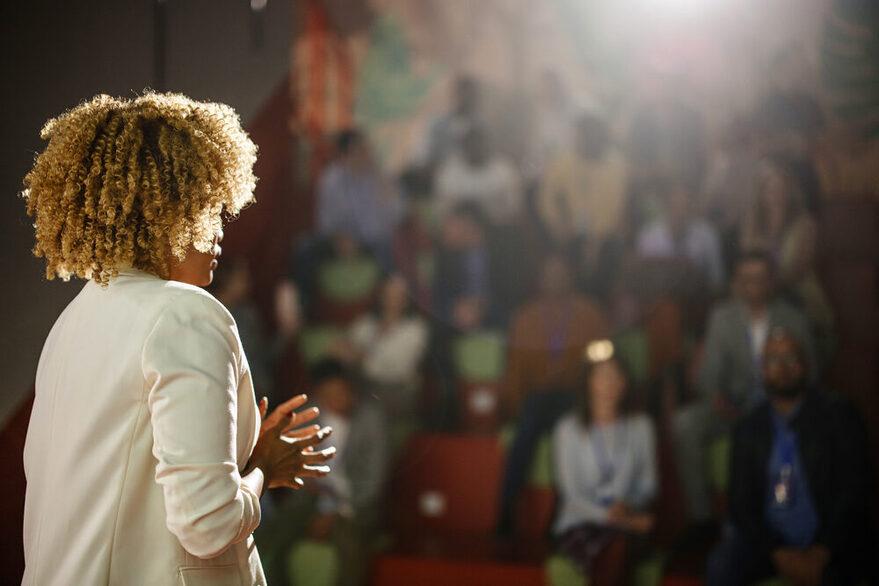 Rear view of the conference speaker giving talk at conference event.