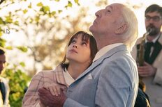 Young woman and older man hold hands and look up at the sky.