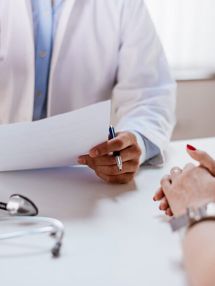 Doctor holds application form during a patient consultation