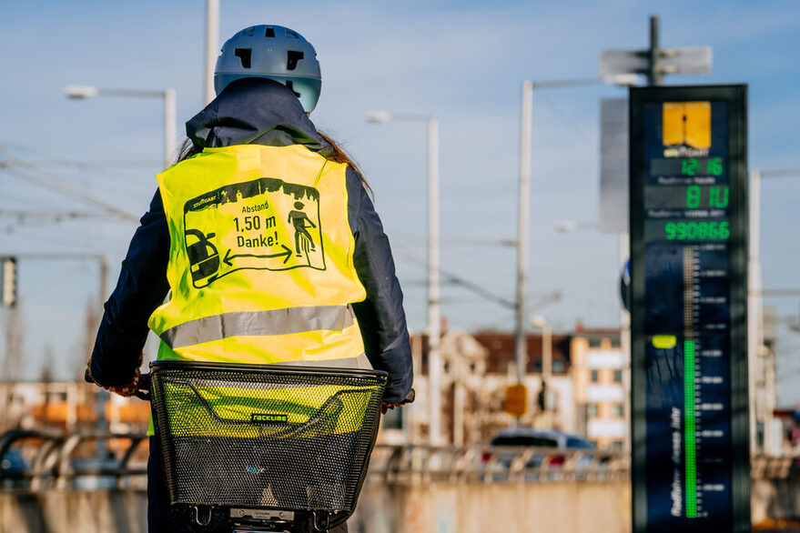 Radfahrerin in Warnweste fährt an einer Zählstation vorbei.