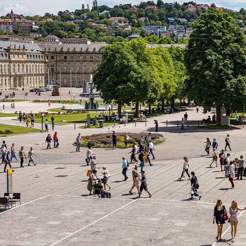 Zahlreiche Menschen sind auf dem Schlossplatz unterwegs bei gutem Wetter.