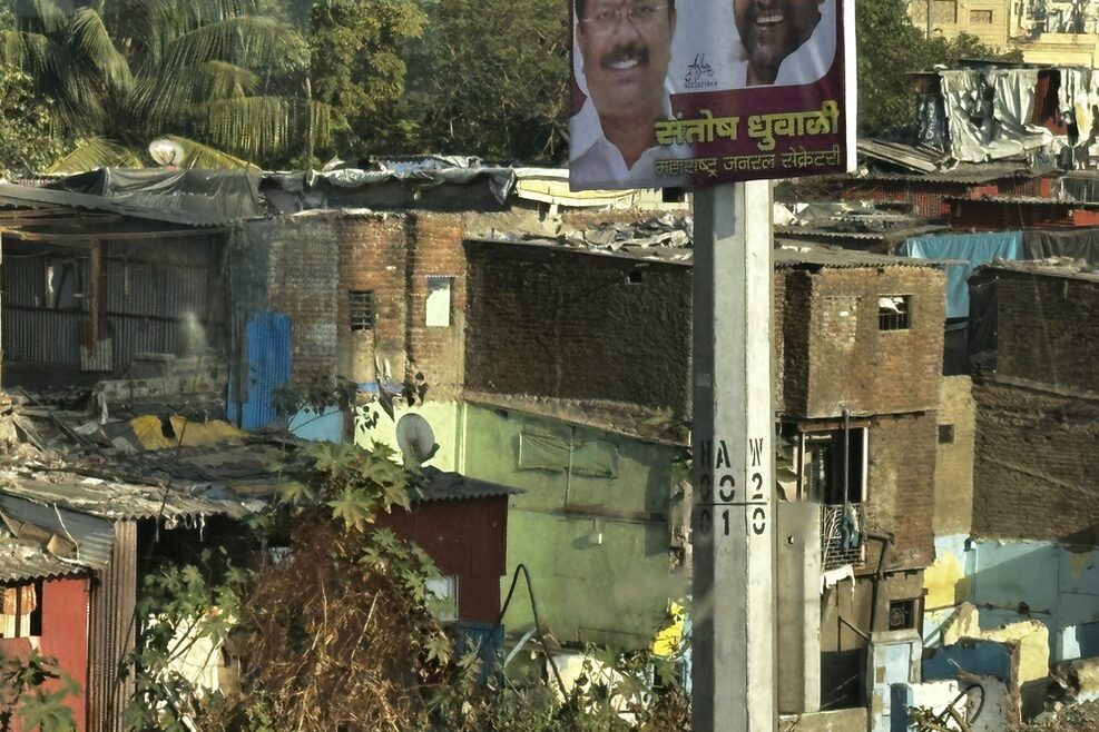 Slums in Mumbai. Im Vordergrund ein Wahlplakat