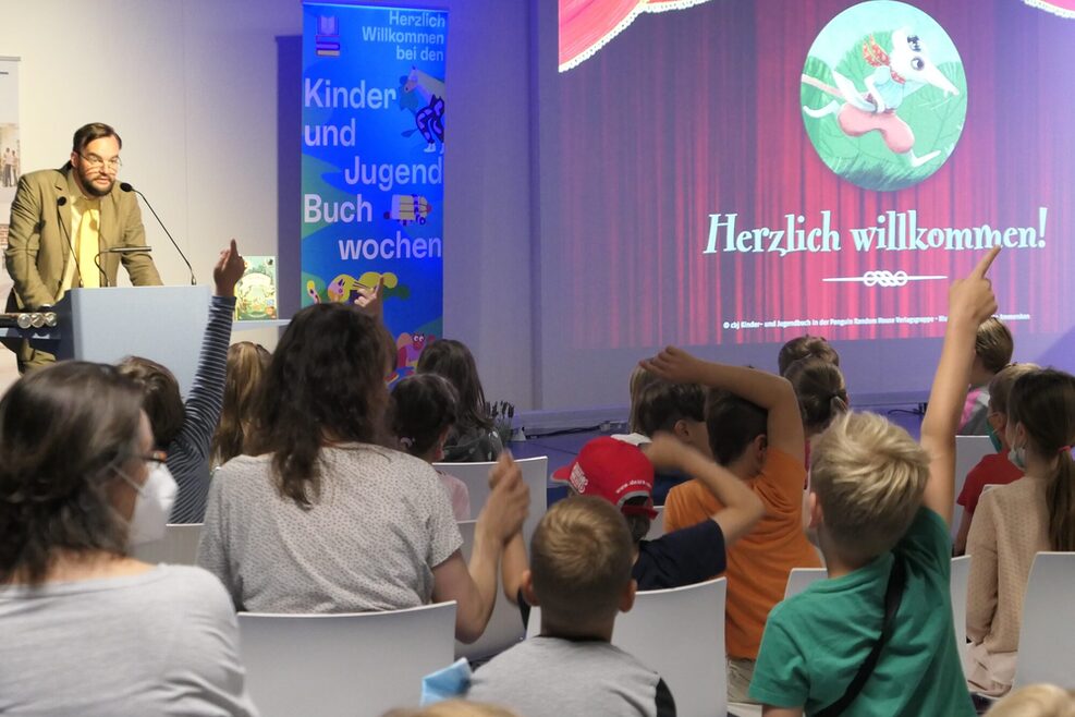 Kulturamtsleiter Herr Gegenfurthner spricht bei den Kinder- und Jugendbuchwochen vor Kindern.