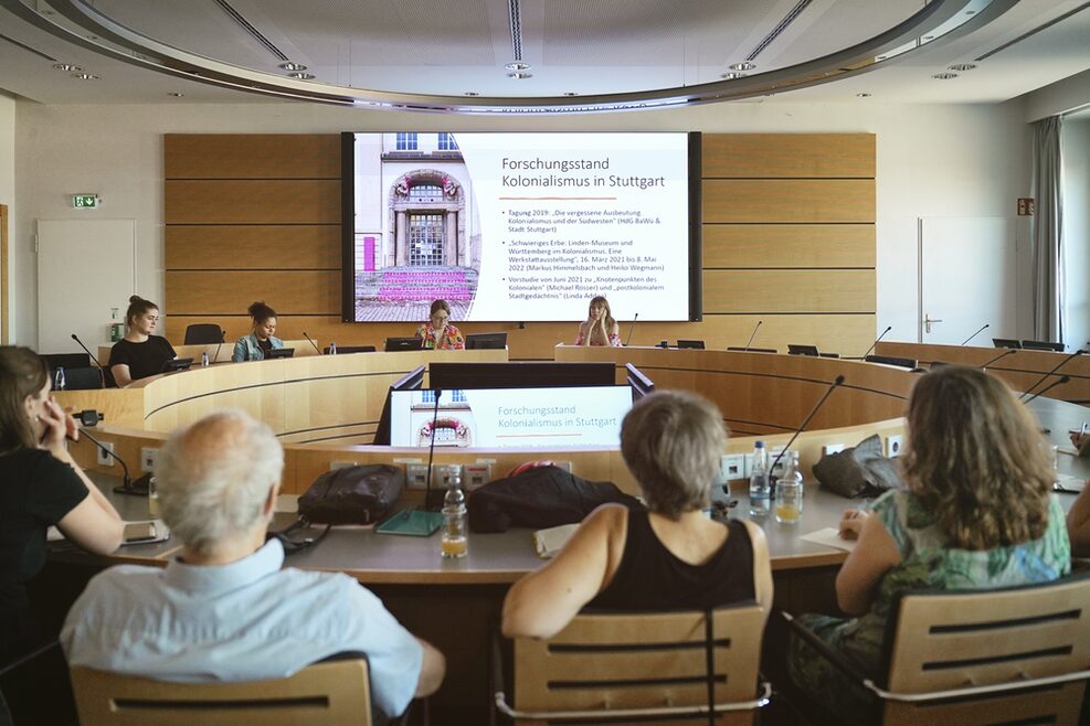 Mehrere Menschen bei einem Vortrag zum Forschungsstand Kolonialismus in Stuttgart.