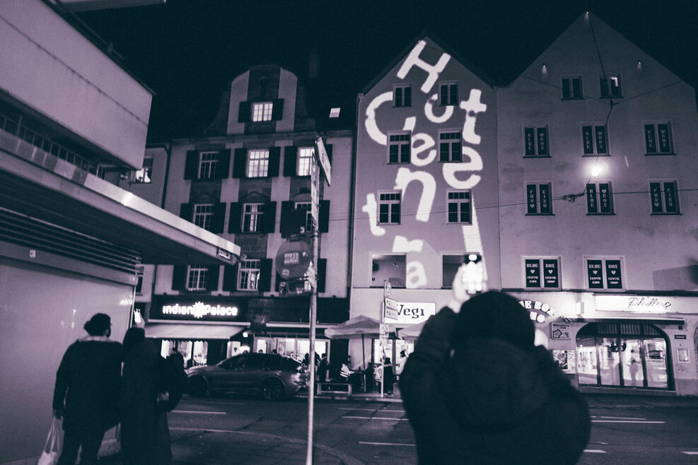 Hotel Central von außen mit Lichtinstalation die den Schriftzug "Hotel Central" zeigt (schwarz-weiß Foto).