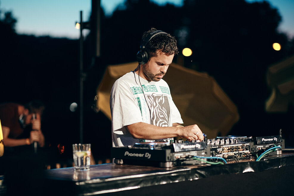 Ein DJ macht vor dem StadtPalais Stuttgart Musik in der Abenddämmerung.