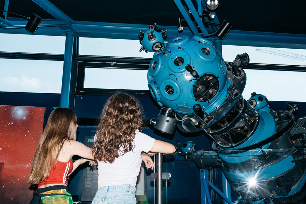 Zwei Mädchen bestaunen den Projektor Modell VI A