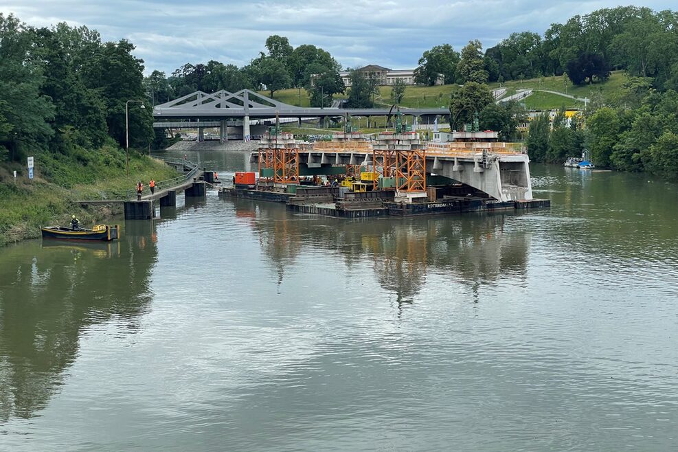 Der abgesägte Brückenträger wird über den Neckar abtransportiert.