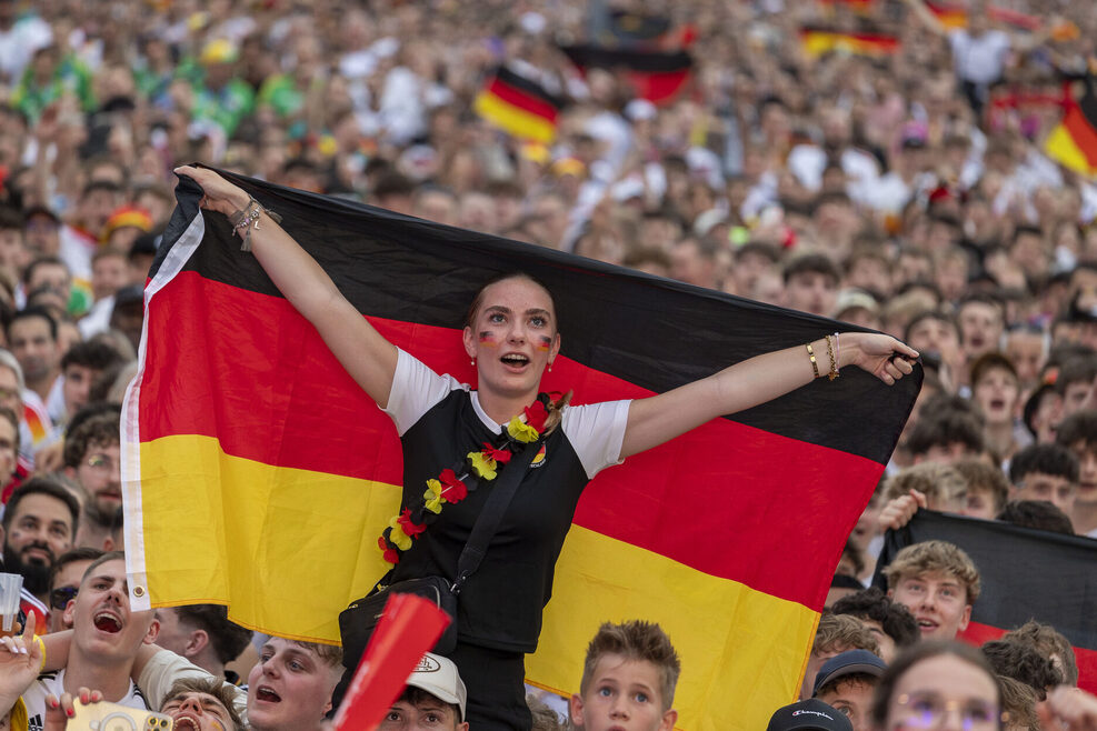 Ein Fan mit Deutschland-Fahne beim Public Viewing auf dem Schlossplatz