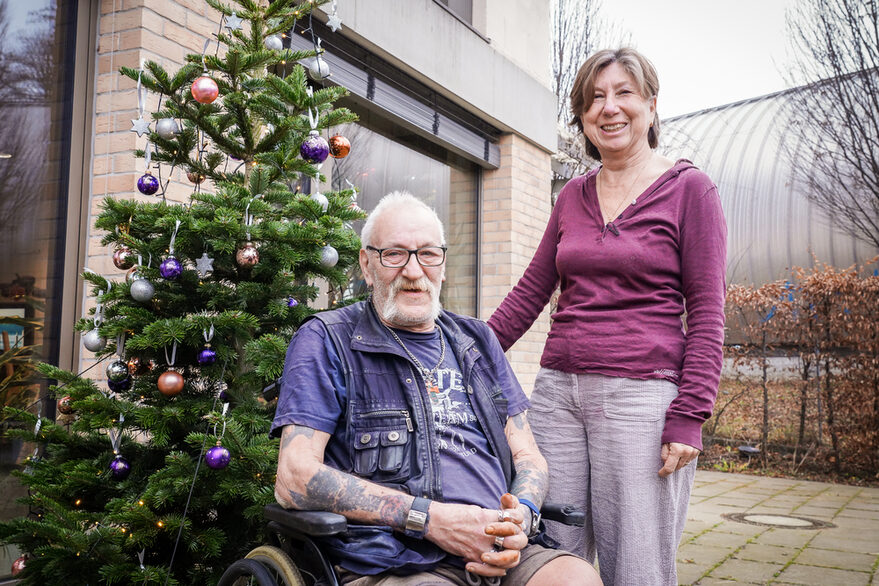 Einrichtungsleiterin Susann Boll-Simmler mit Männerwohnheimbewohner Bernhard Hudelmaier vor einem Weihnachtsbaum.