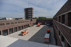 Mehrere Feuerwehrfahrzeuge stehen auf dem Hof der Feuerwache 5 in Stuttgart Möhringen. Etwa die Hälfte des Hofes und der umliegenden Backsteingebäude liegn im Schatten.