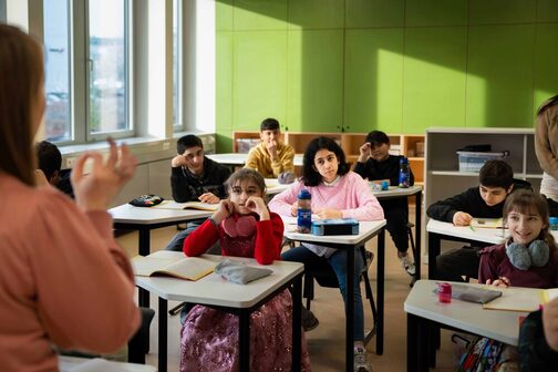 Kinder sitzen in einem Lernraum