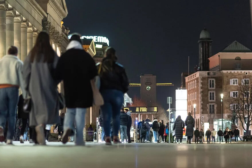 Menschen laufen bei Nacht auf der Königstraße.