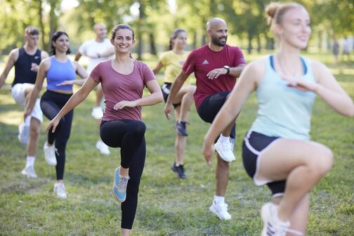 Mehrere Personen machen Sportübungen in einem Park