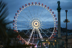 Das Riesenrad auf dem Schlossplatz leuchtet in der Dämmerung.