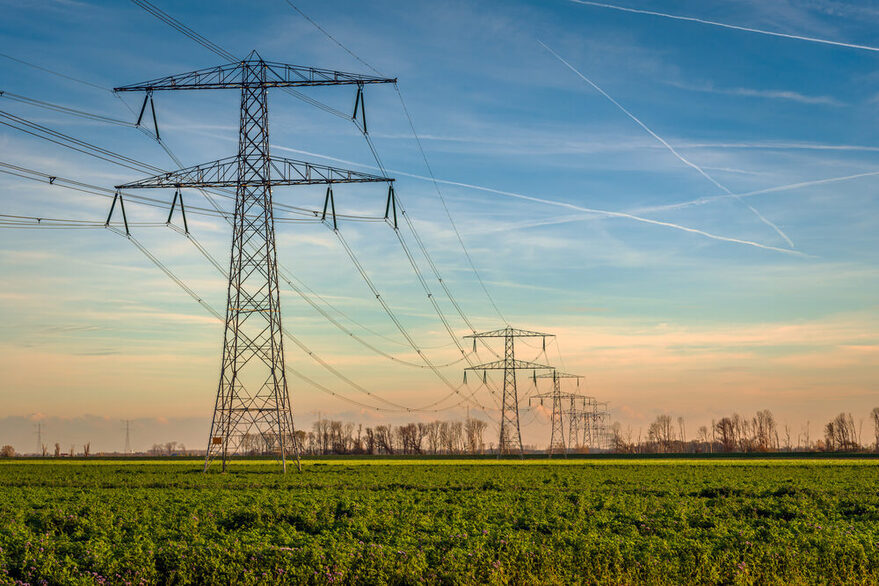 Hochspannungsmasten mit hängenden Stromkabeln in einer ländlichen Landschaft