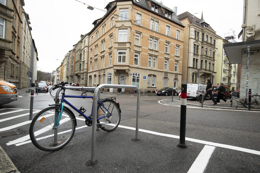 Eine Stuttgarter Ecke mit Bodenmarkierungen, Pollern und Abstellmöglichkeiten für Fahrräder.