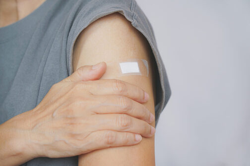 Upper arm of a woman with a plaster after a vaccination