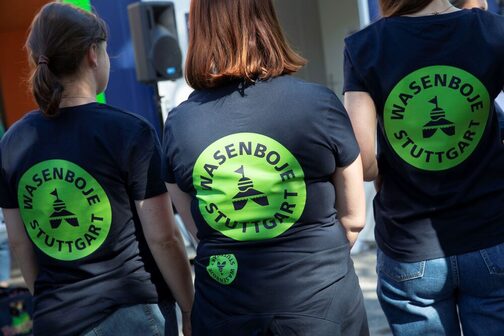 Drei Frauen tragen T-Shirts mit einem "Wasenboje Stuttgart" Aufdruck.