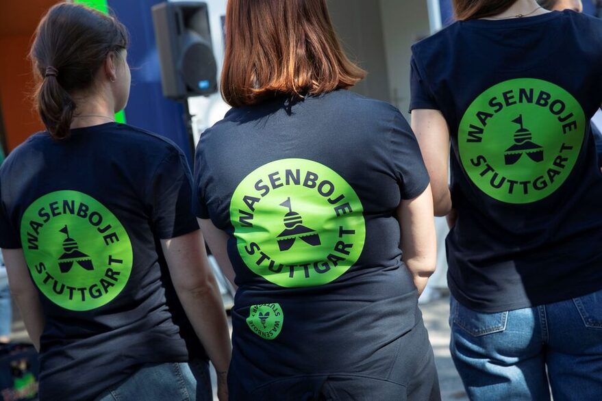 Drei Frauen tragen T-Shirts mit einem "Wasenboje Stuttgart" Aufdruck.