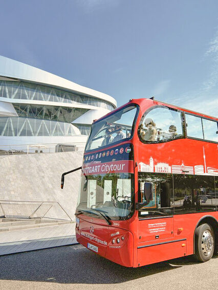 Ein roter Stuttgart Citytour-Bus steht vor dem Mercedes Benz-Museum.