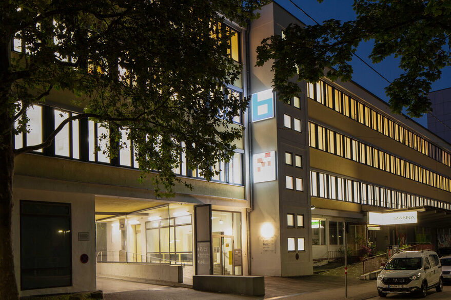 Gebäude der Stadtteilbibliothek Bad Cannstatt mit Beleuchtung bei Nacht.