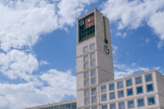 Turm des Rathauses, dahinter weiße Wolken bei blauem Himmel