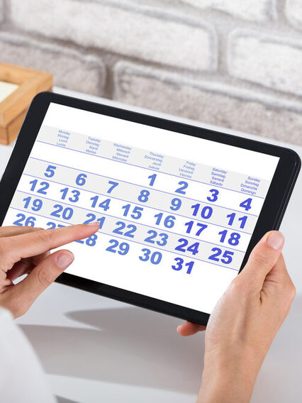 Businessperson Holding Digital Tablet With Calendar On Screen